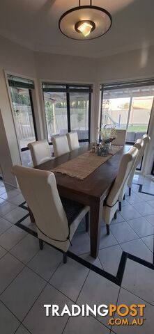 a dining table with 8 leather chairs.